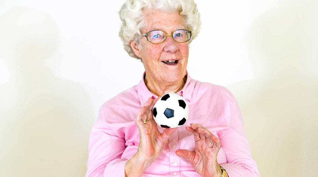 Elderly Woman Playing Catch with Small Soccer Ball